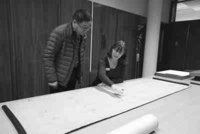 11月2日，在英国纽卡斯尔的泰恩—威尔档案馆，档案管理员瑞秋·吉尔（右）向记者介绍致远舰设计图纸。新华社